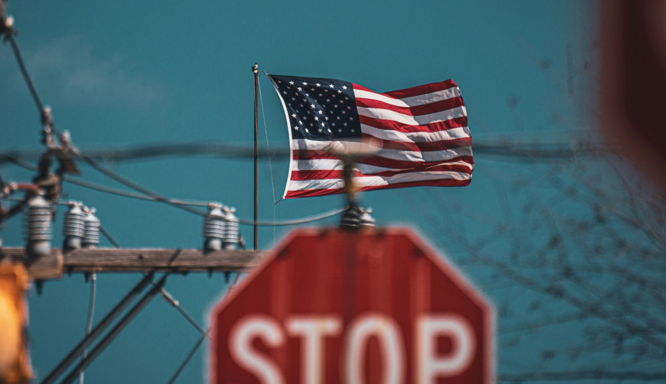 Amerikanska flaggan vajar ovanför en stoppskylt.