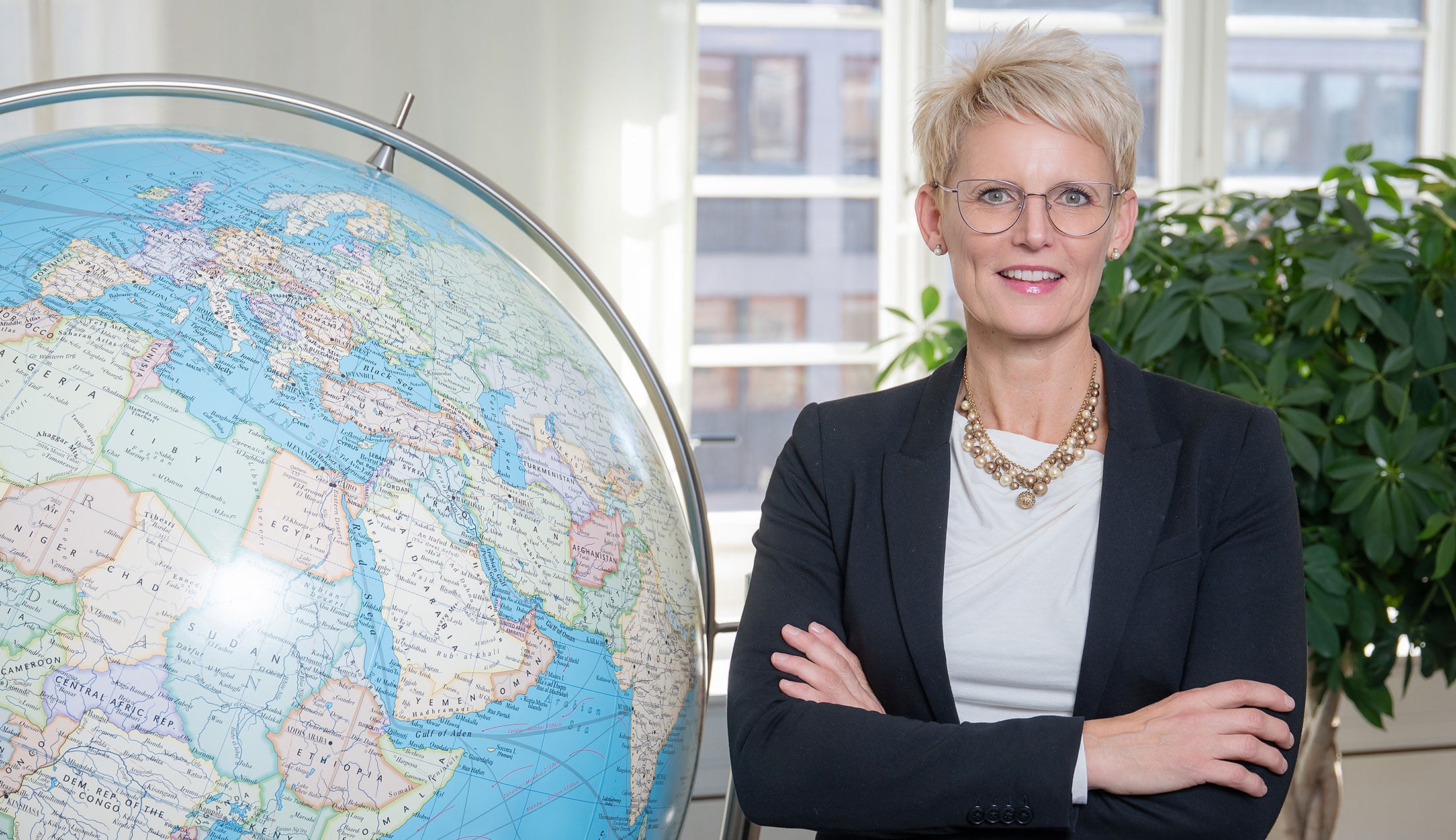 Åsa Larsson står bredvid en stor jordglob