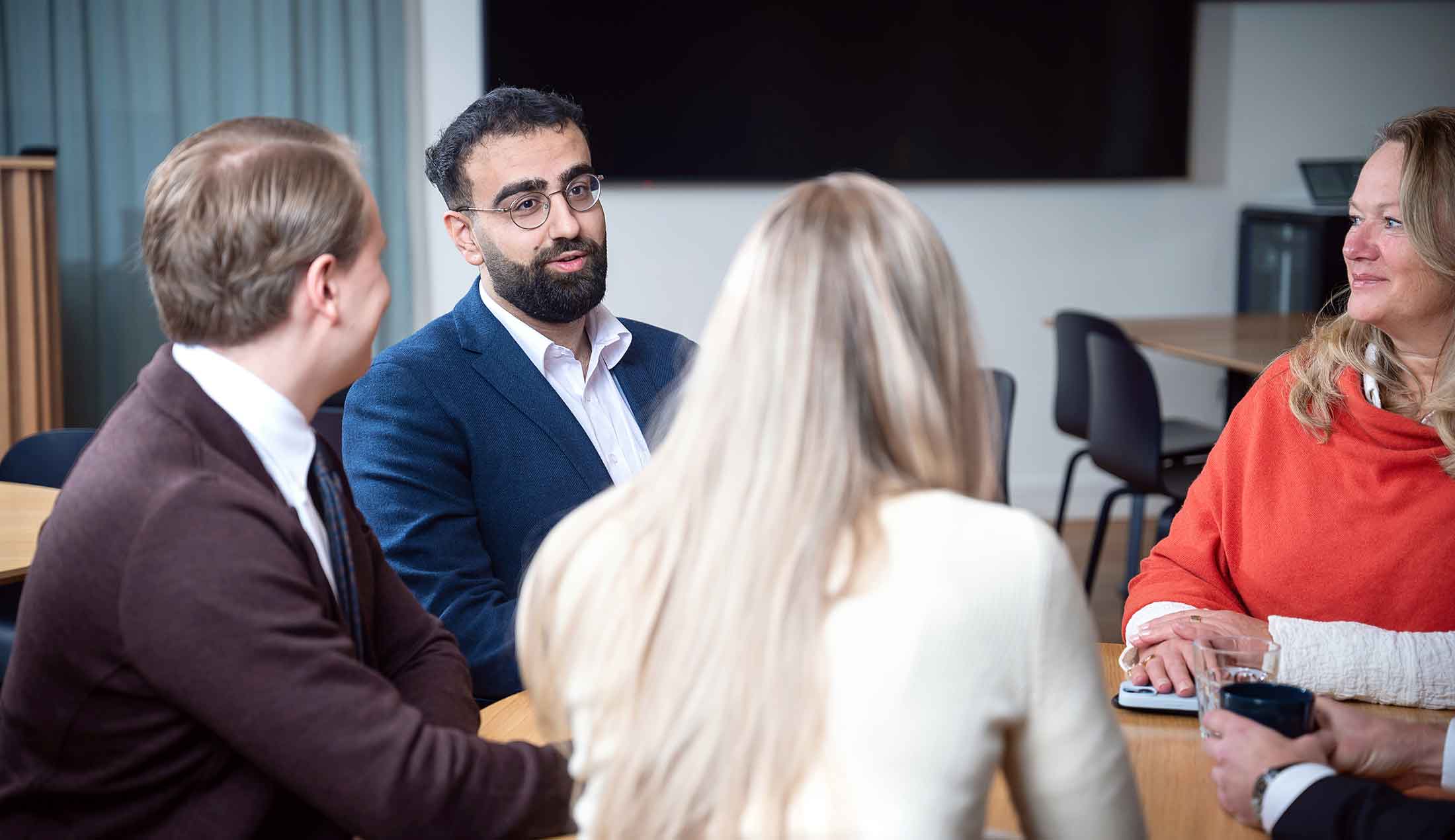 Ghanim Matti sits at a table together with a couple of colleagues.