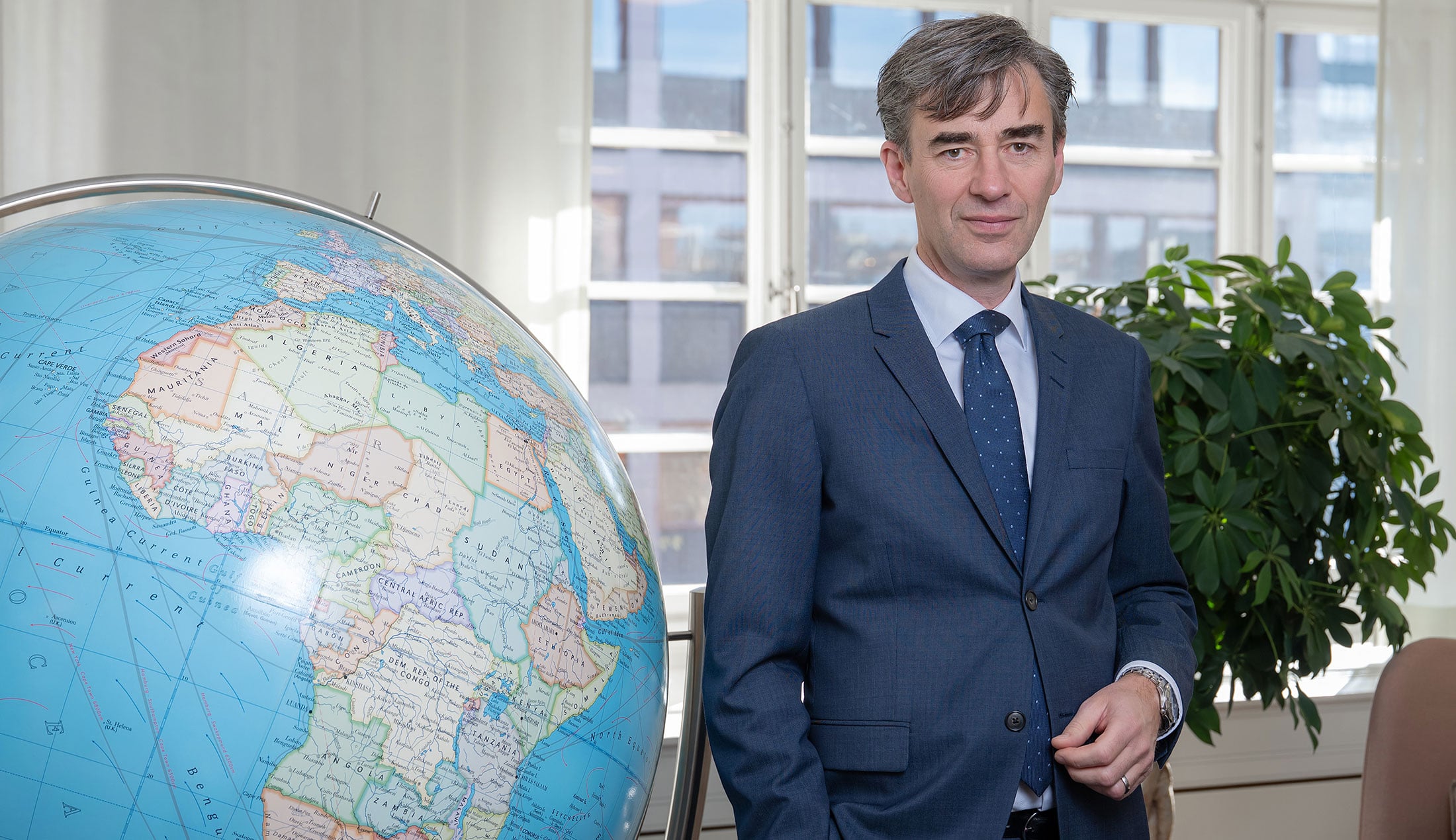 Ove Nyström, EKN’s Director of Large Corporates, standing beside a large globe in an office.