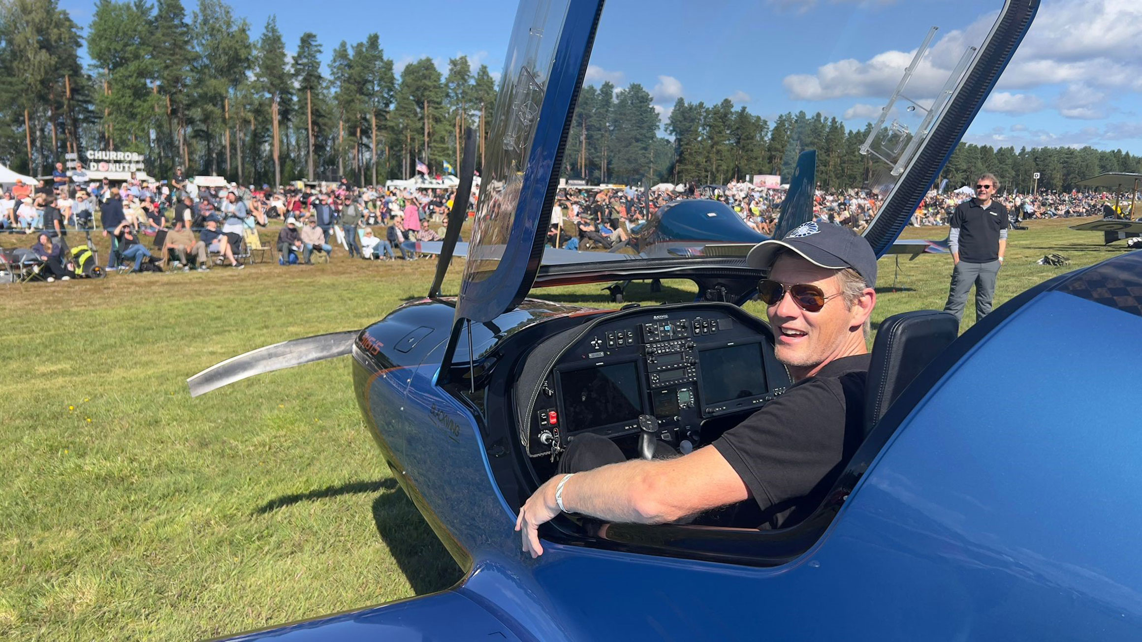 Niklas Anderberg sitter i ett av sina plan med en stor publik i bakgrunden.