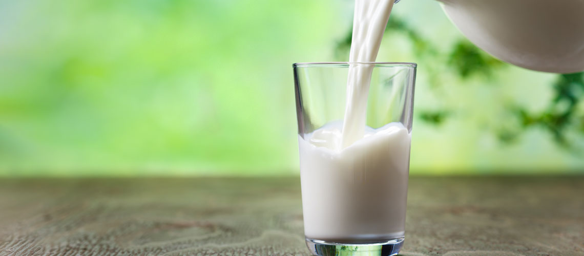 Milk pouring from a jug to a glass