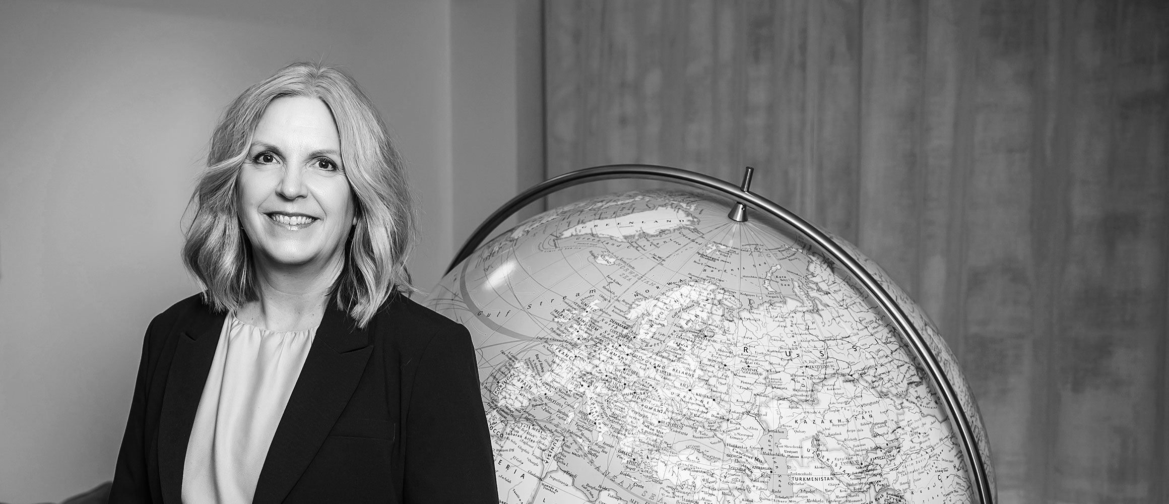 Anna Långström står framför en stor jordglob