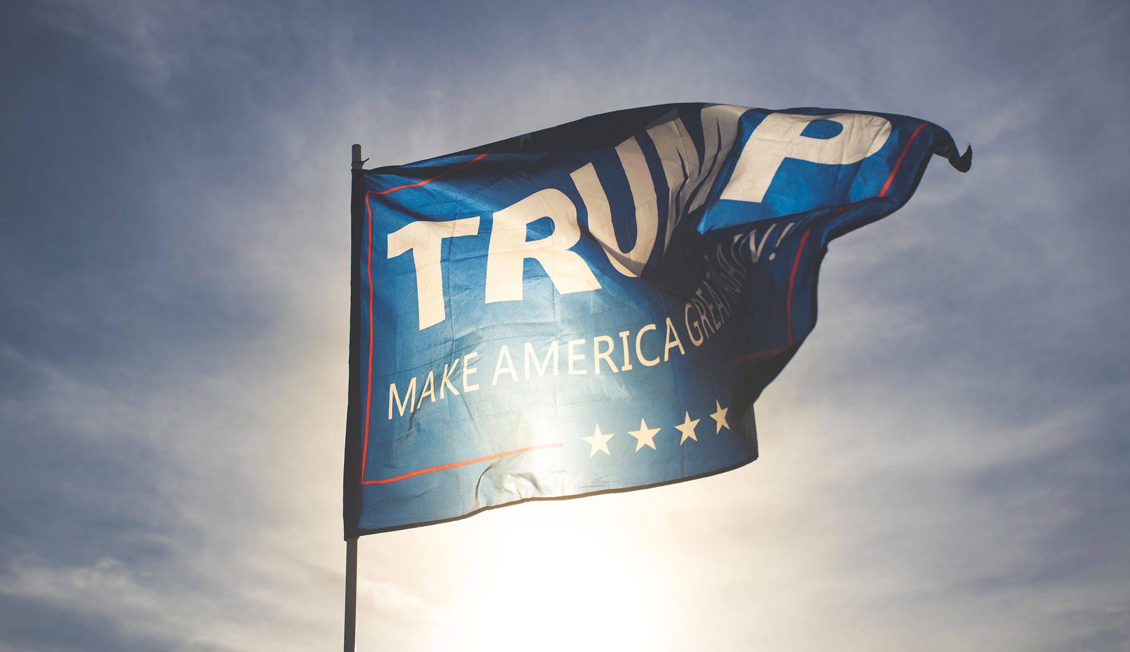 En flaggar vajar i vinden. På flaggan står "TRUMP MAKE AMERICA GREAT AGAIN!".