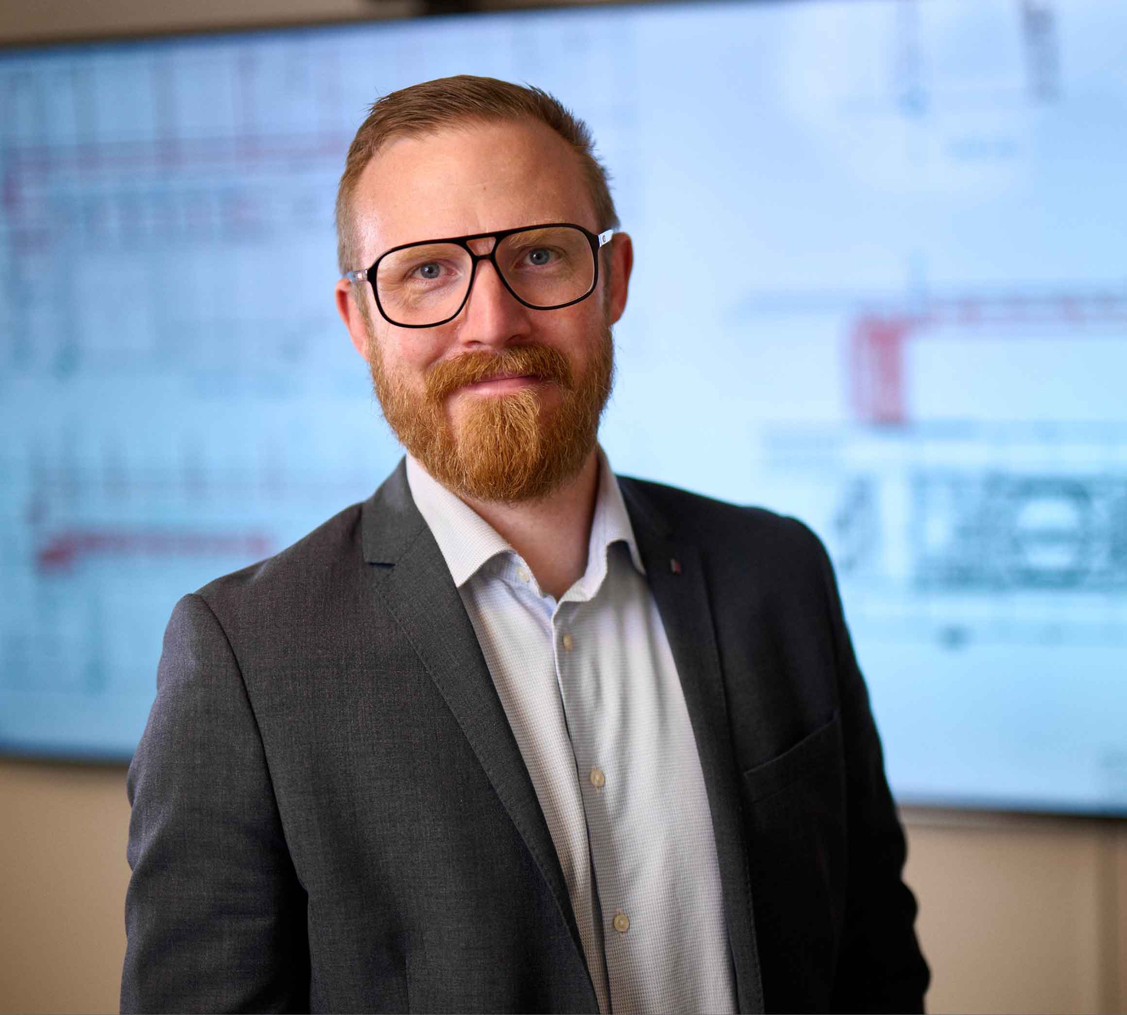 Carl-Johan Fagerström står framför en stor tv-skärm