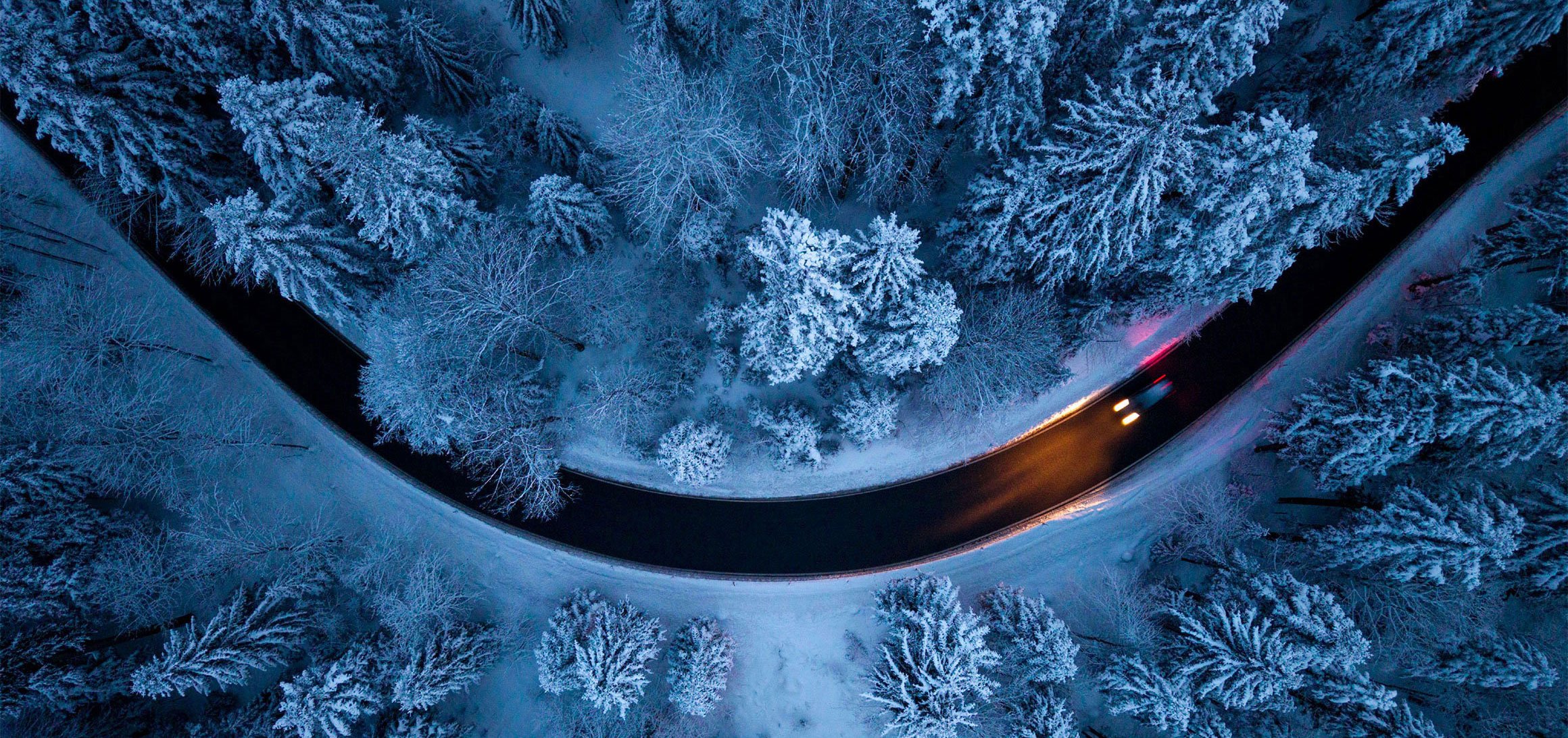 Väg som går genom vinterlandskap sedd från luften.