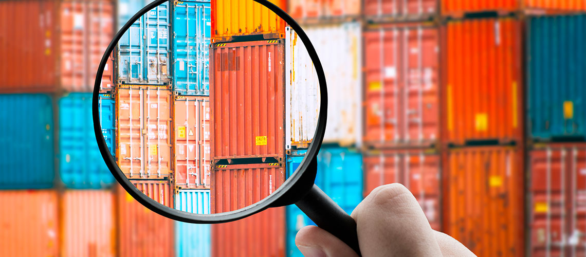 Dekorativ bild på lastcontainer igenom ett förstoringsglas