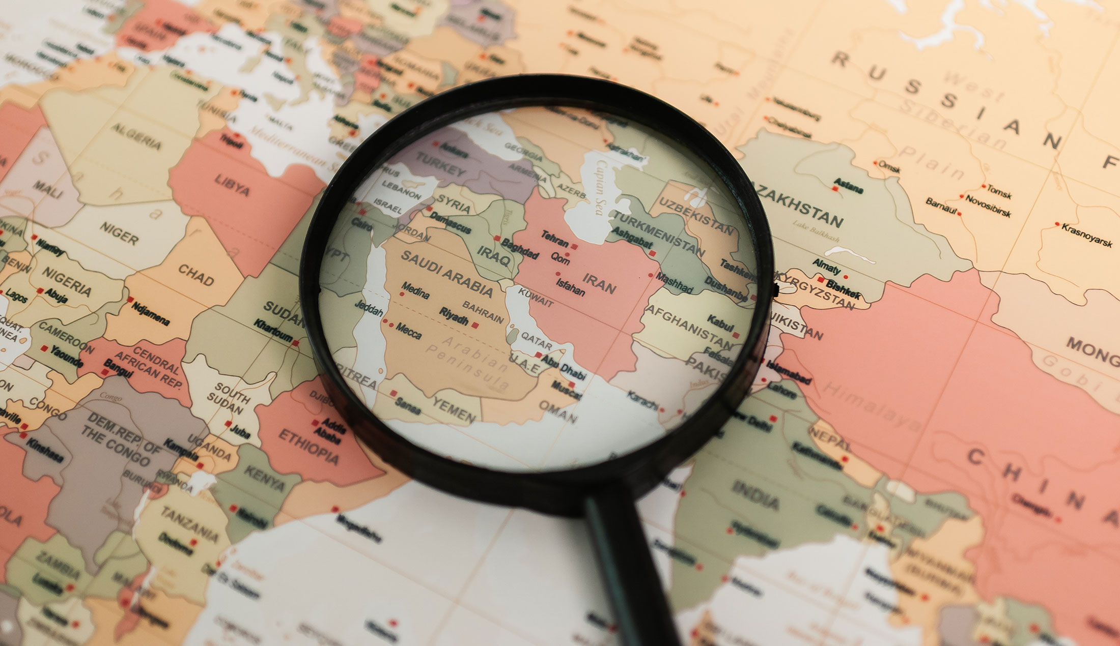 Ett förstoringsglas ligger över Iran och omkringliggande länder på en karta som visar delar av Asien och Afrika.