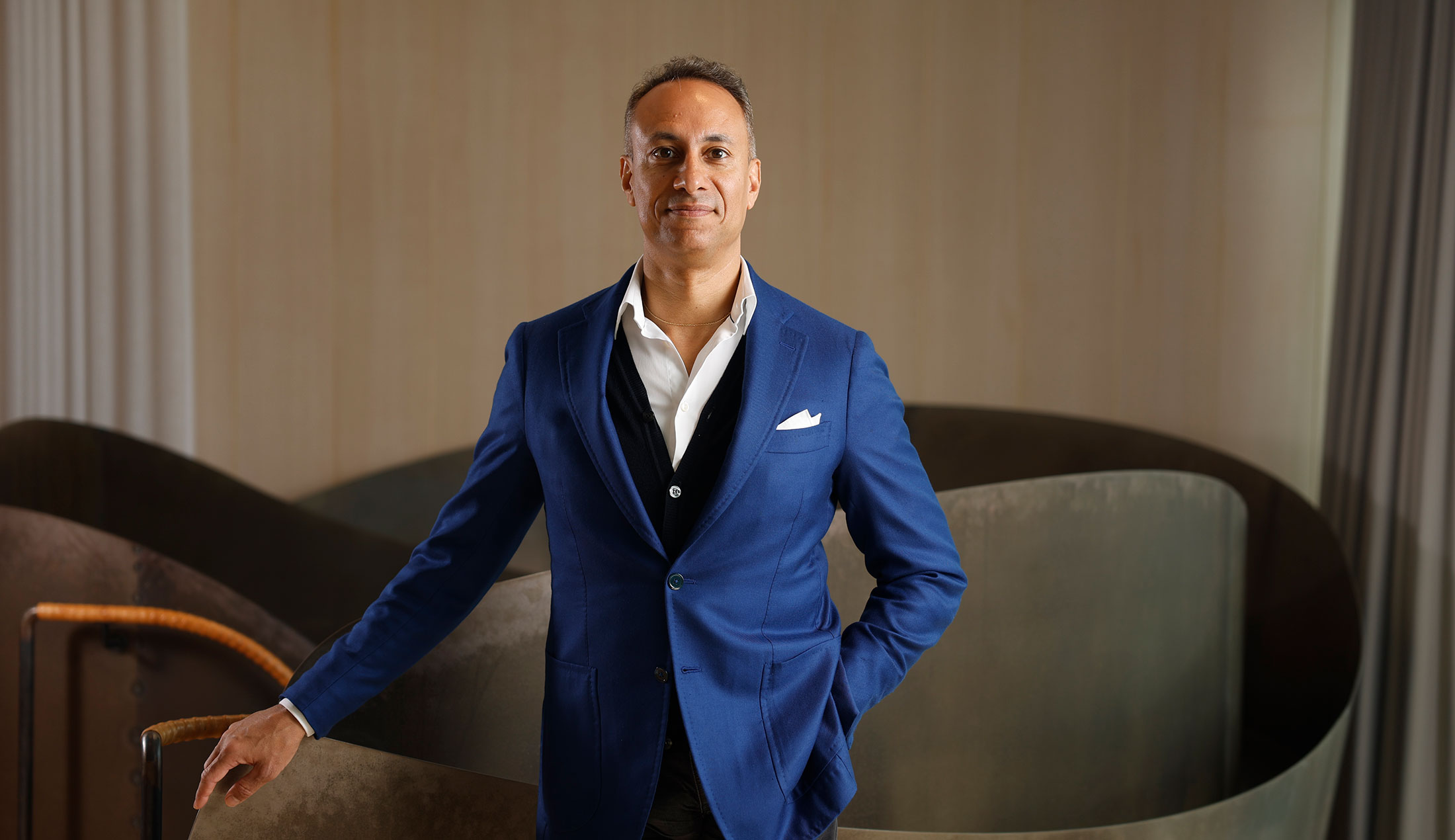 Klas Tikkanen står framför en skulptur och tittar in i kameran.