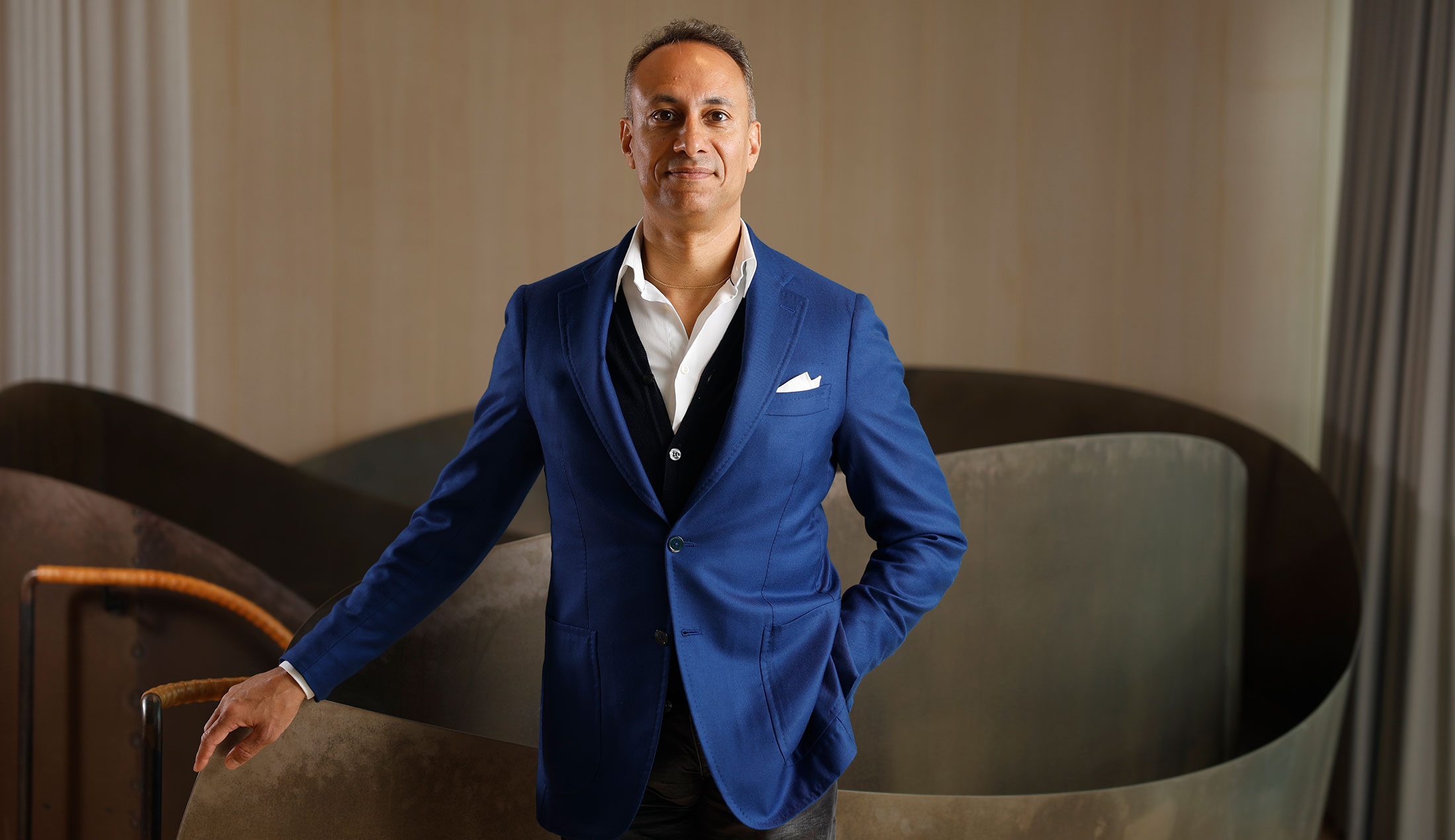 Klas Tikkanen står framför en skulptur och tittar in i kameran.