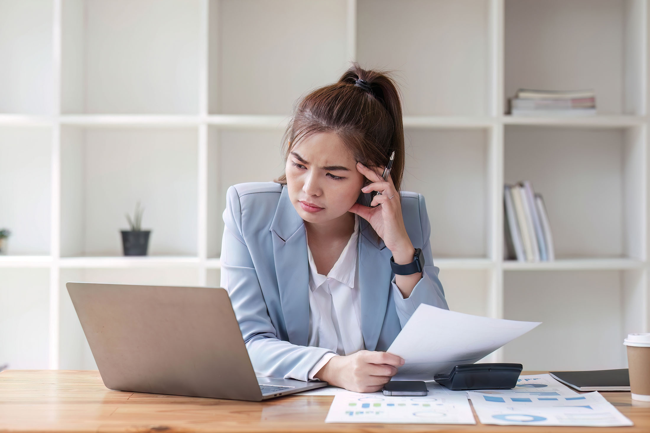 Woman sitting at computer. Looks puzzled.