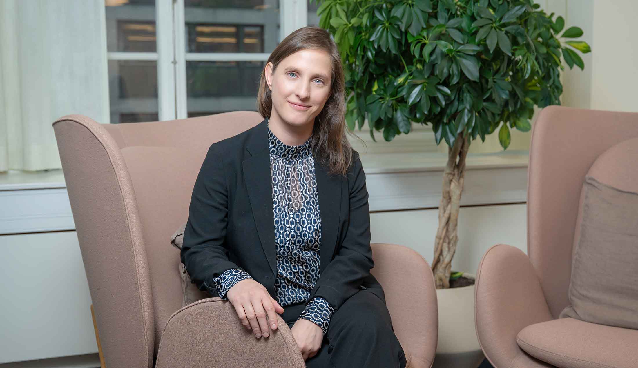 Johanna sitter i en fåtölj och tittar in i kameran.