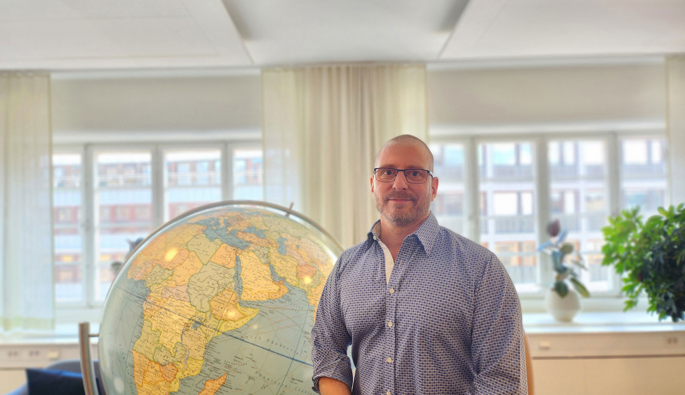 Robert står framför en stor jordglob