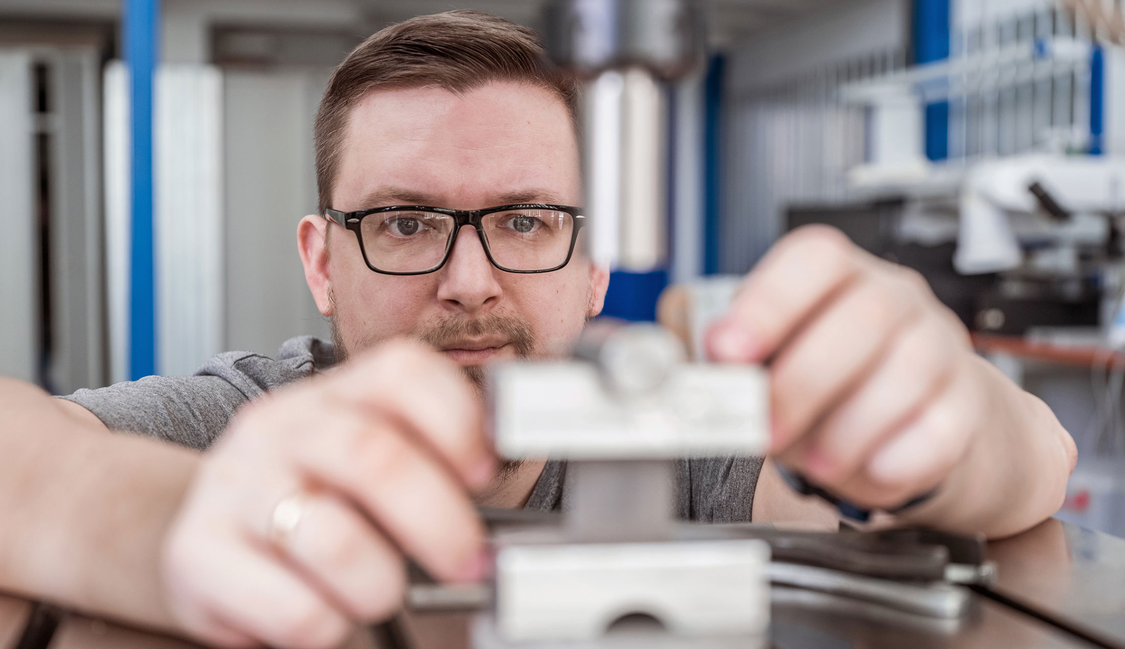 En man monterar komponenter i industrimiljö