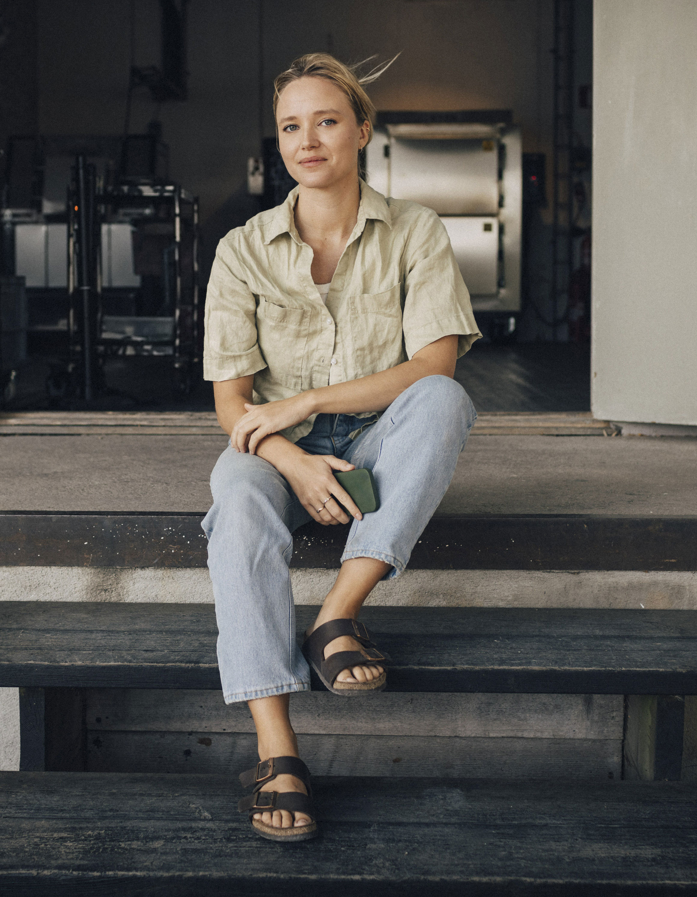 Ung kvinna sitter i en trappa och ler mot kameran