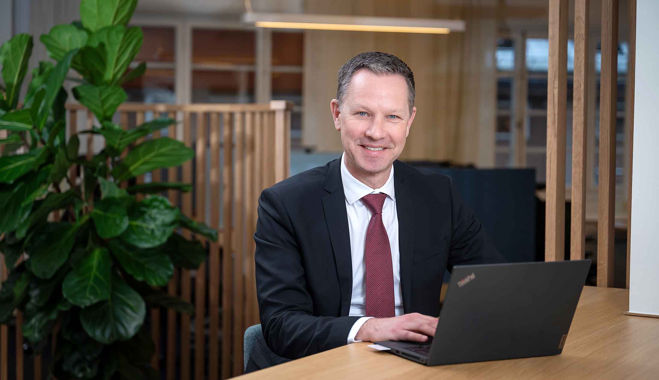 Kristian sitter vid ett bord och arbetar på sin dator